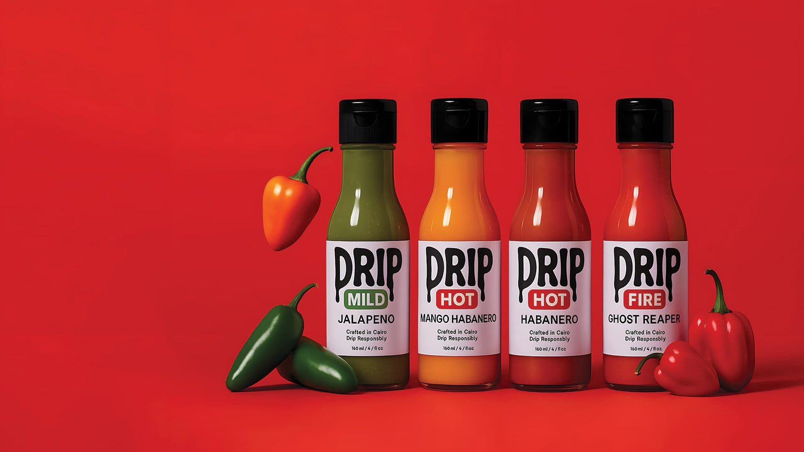 Five bottles of Drip hot sauce with peppers on a red background